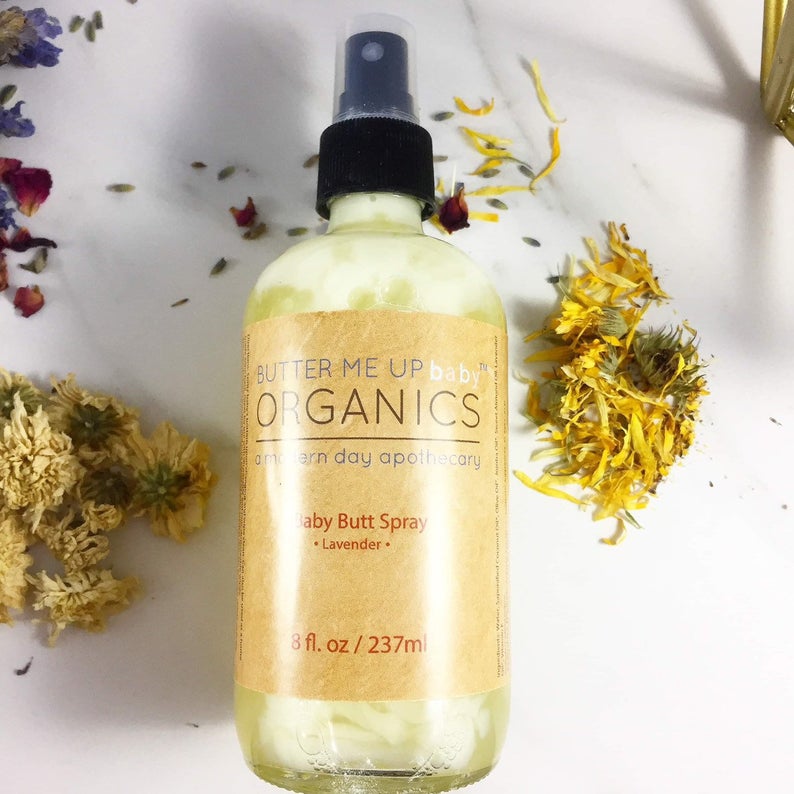Butter Me Up Organics baby butt spray bottle with dried flowers on a white background
