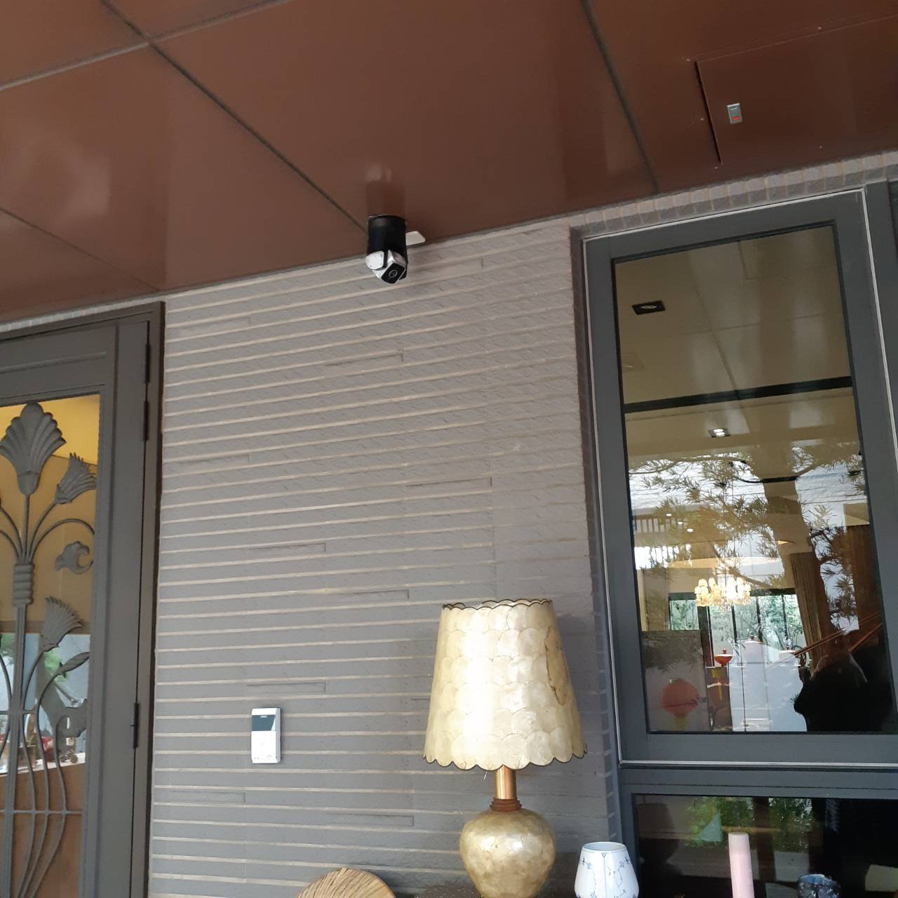 Lamp on a table next to a sliding glass door with a view of a room.