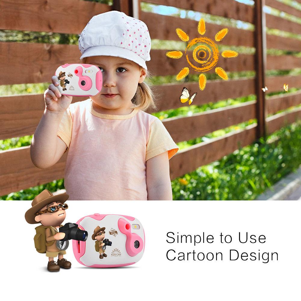 Child holding a pink toy camera with cartoon design, outdoors.
