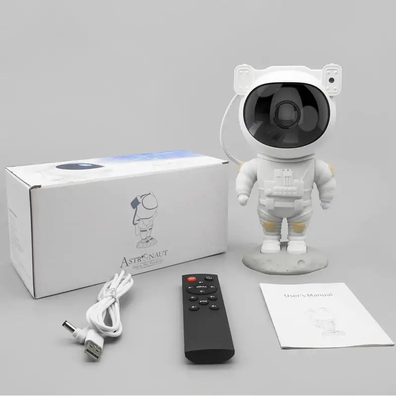 White astronaut figurine with packaging, remote control, and manual on a gray background