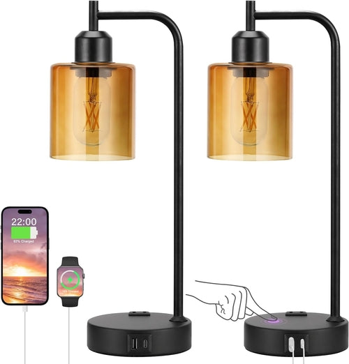Black table lamp with two amber glass shades, charging phone and watch on a white background.