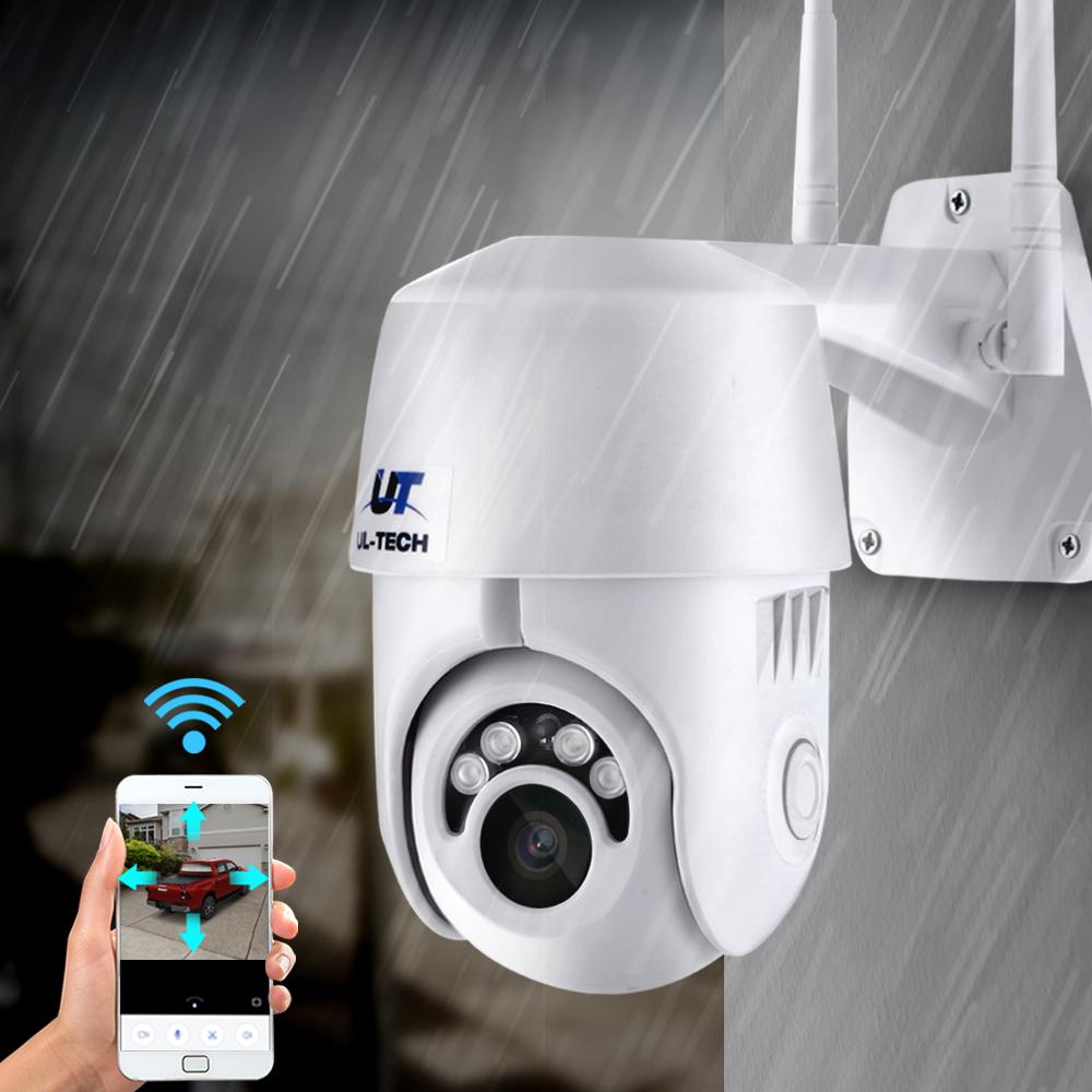 White security camera with UT Tech logo on a rainy background, showing a smartphone app interface.