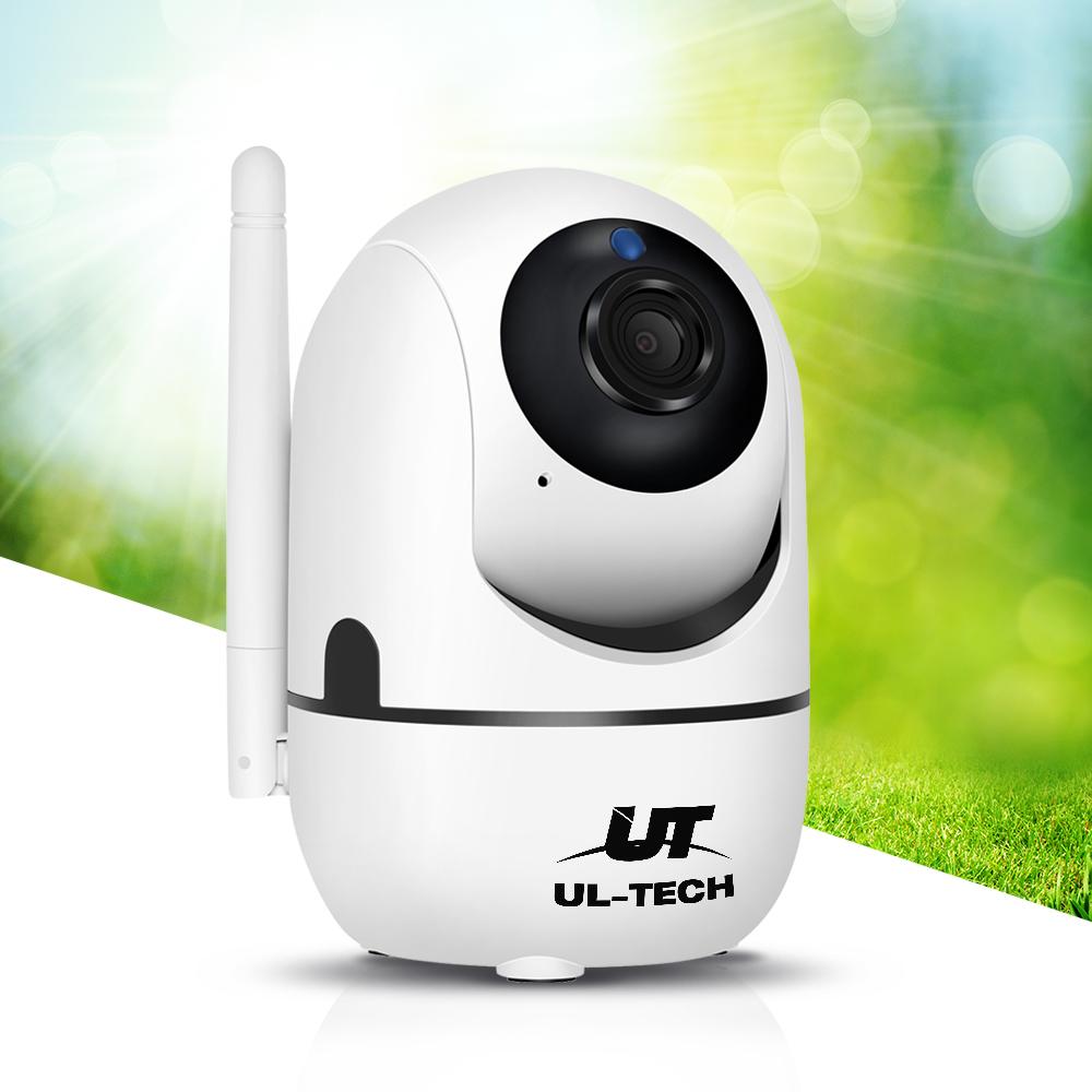 White security camera with black lens and UT Tech logo on a blurred green outdoor background