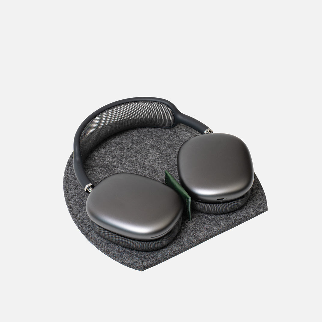 Gray headphones on a matching gray cushion with a white background