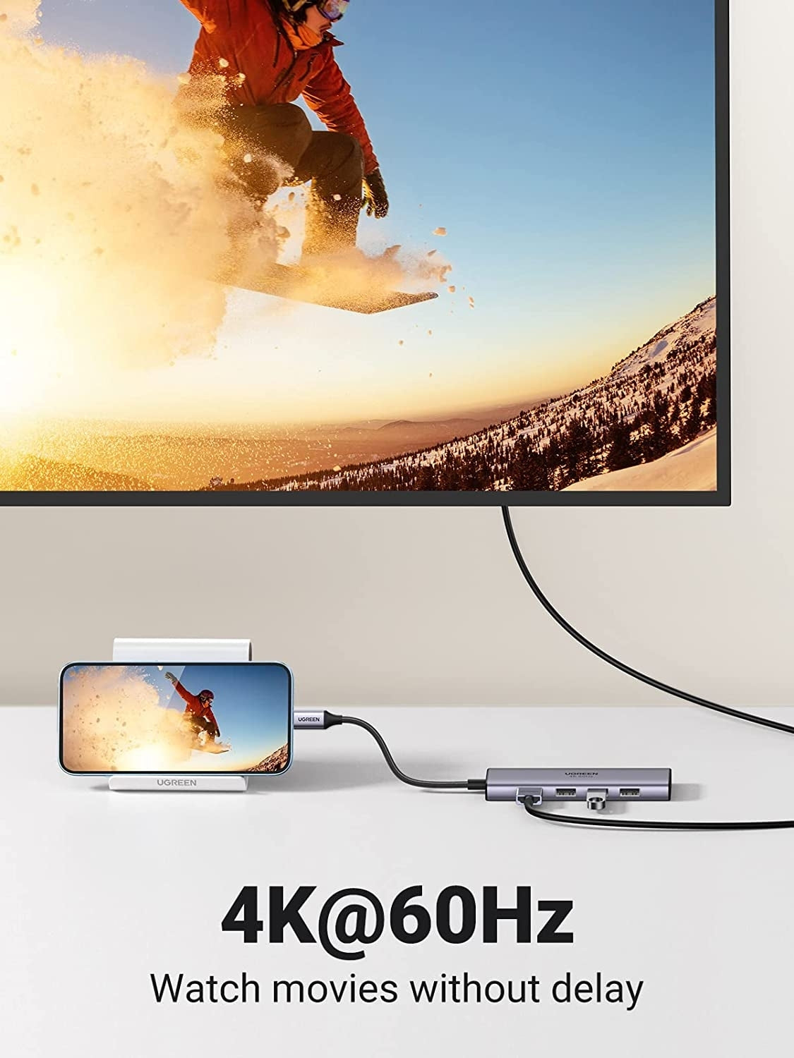 TV screen displaying a snowboarder, with a smartphone showing the same scene, connected by a cable. Text '4K@60Hz Watch movies without delay' below.