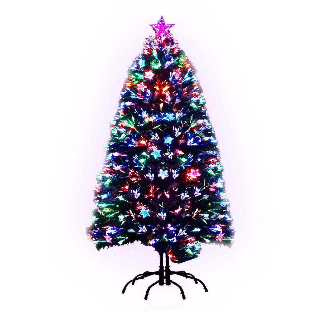 A tall, conical Christmas tree with dense green branches, decorated with numerous multicolored string lights and a pink star topper, standing on a black metal stand against a white background. Axis-Dynamics online retail store