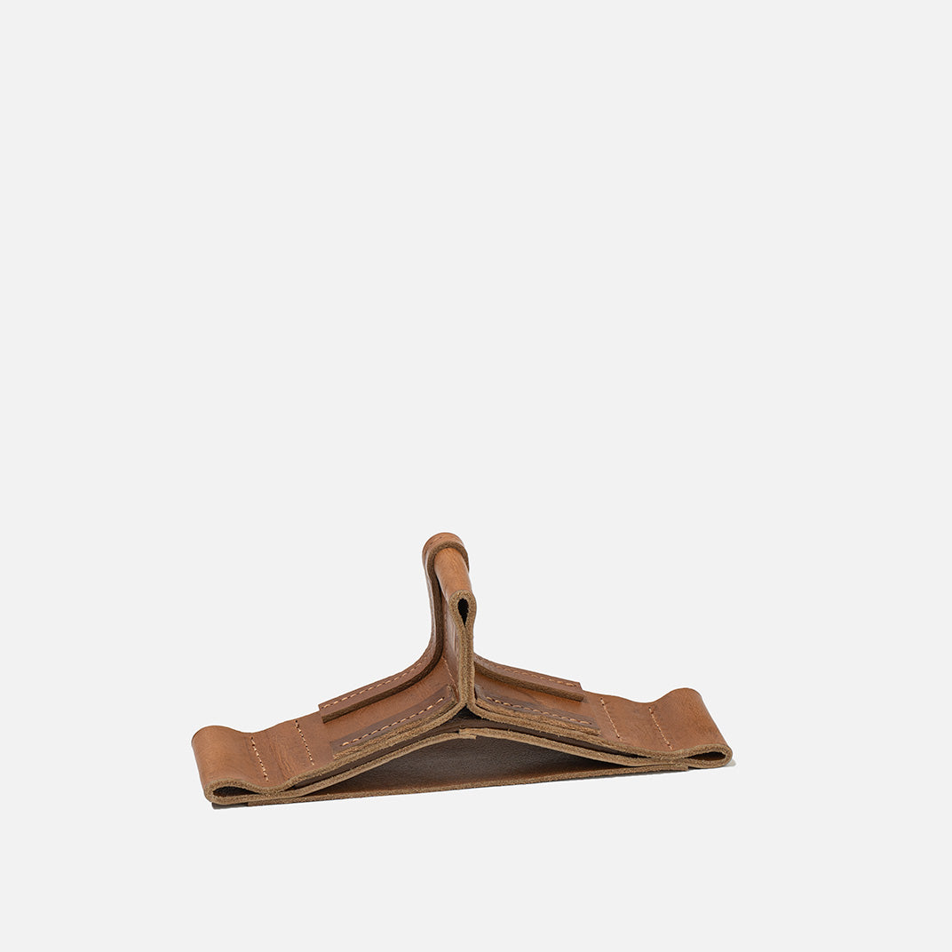 Brown leather hanger on a light gray background