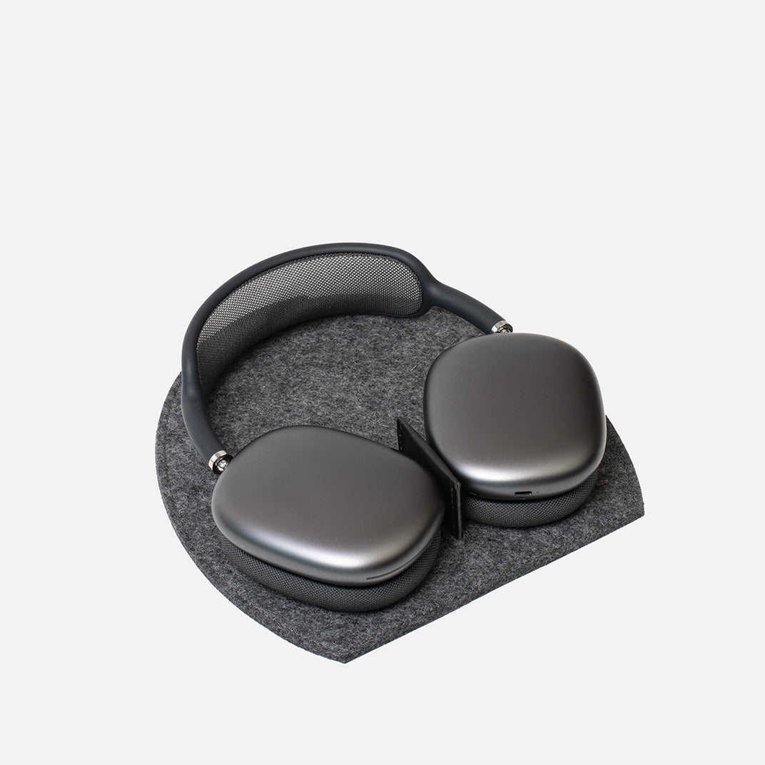 Gray headphones on a gray cushion with a white background