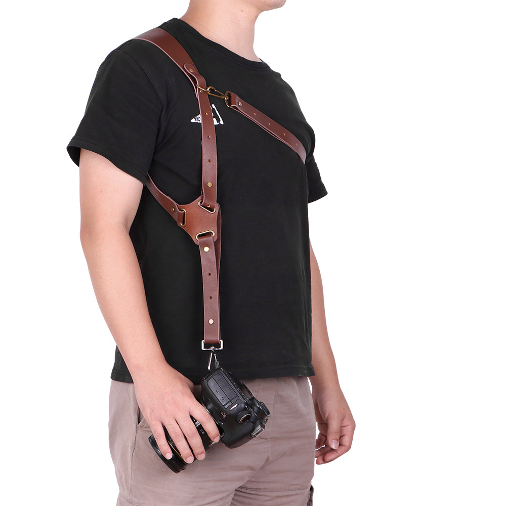 Person wearing a brown leather camera strap over a black shirt on a white background