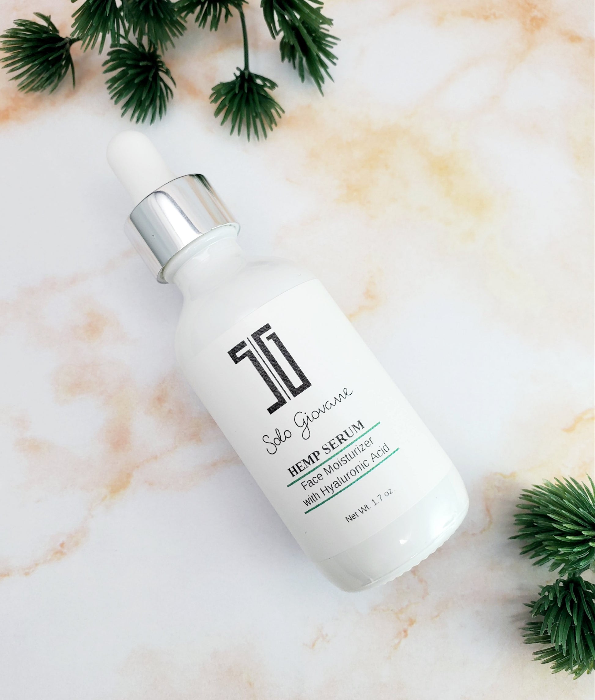 Skincare serum bottle on a marble surface with green leaves. deep hydrating body butter for winter dry skin and online store. Axis-Dynamics
