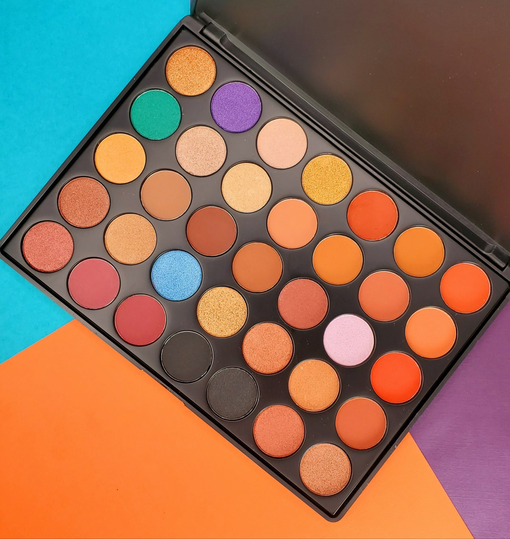 Makeup palette with colorful eyeshadows on a multicolored background. Best online retail store. Axis-Dynamics
