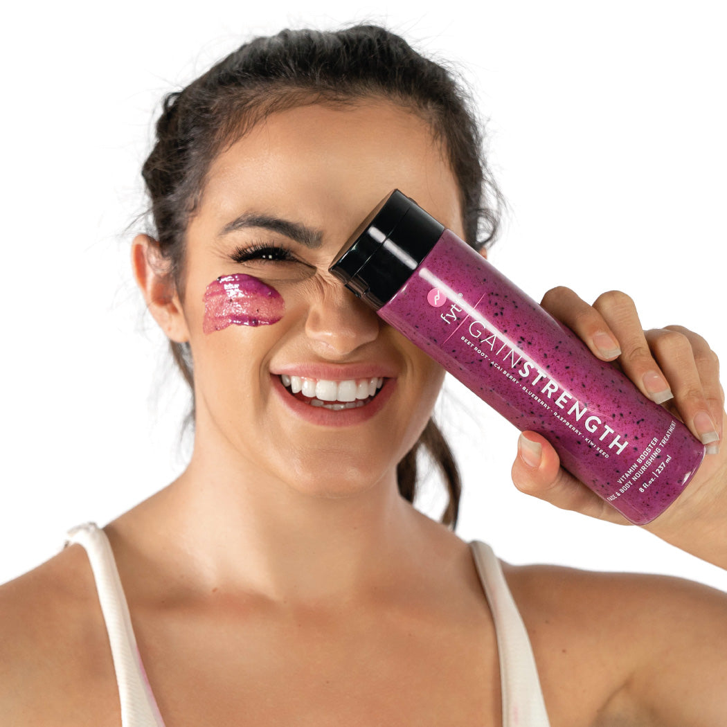 Woman holding a purple bottle labeled 'Gainstrength' with a white background. Best online retail store. Axis-Dynamics