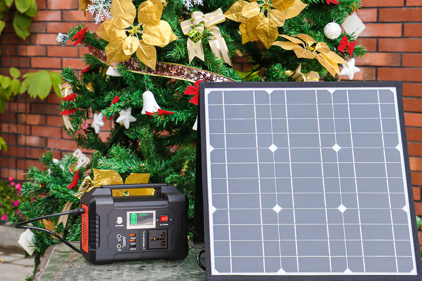 Solar panel and power station in front of a decorated Christmas tree.