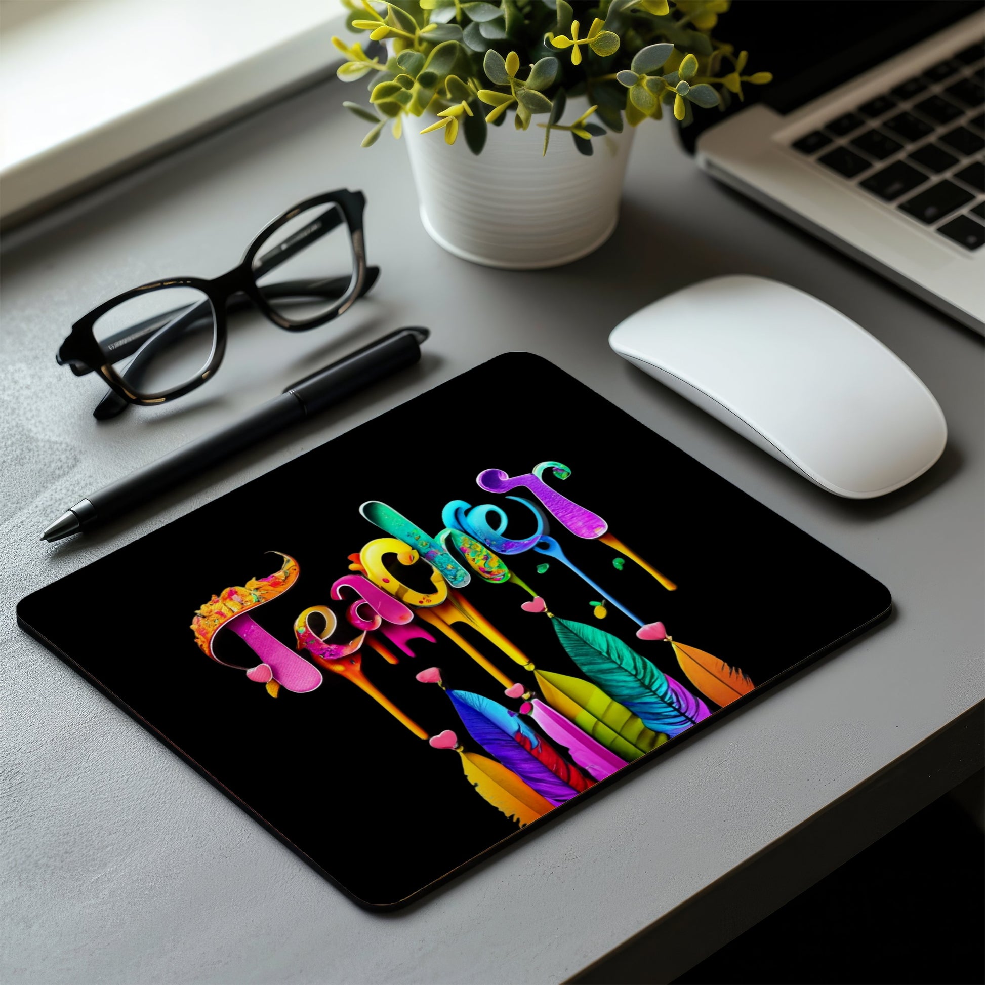 Colorful 'Teacher' design mouse pad on a desk with a laptop, mouse, and glasses. Best electronics online store near me. Axis-Dynamics
