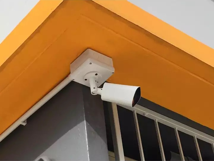 Security camera mounted on a yellow and gray wall