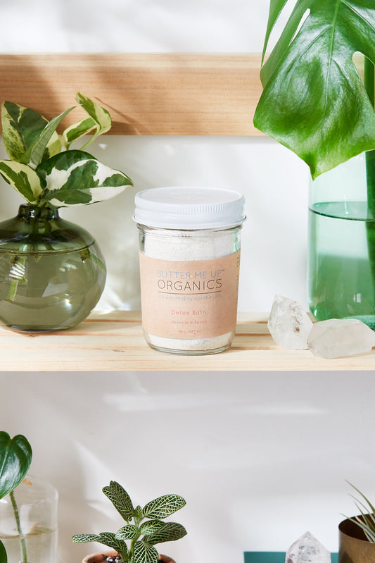 Jar labeled 'Organics' on a shelf with plants and crystals. deep hydrating body butter for winter dry skin and online store. Axis-Dynamics
