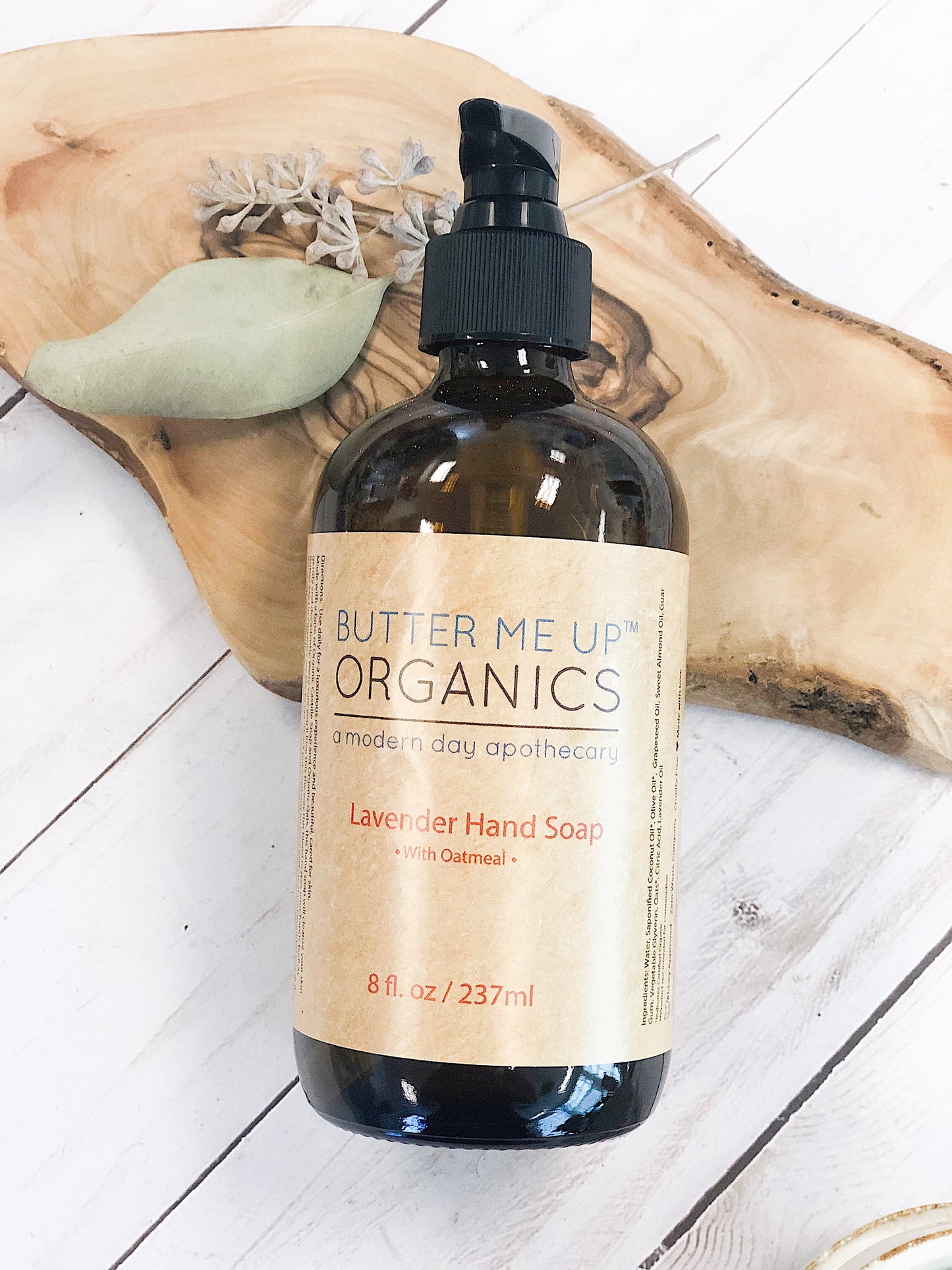 Butter Me Up Organics lavender hand soap bottle on a wooden surface. deep hydrating body butter for winter dry skin and online store. Axis-Dynamics