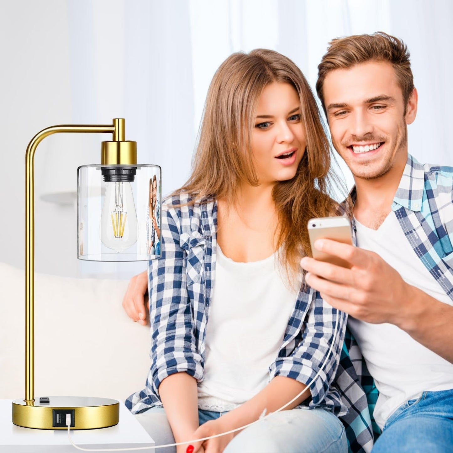 Man and woman sitting together with a smartphone, next to a gold desk lamp.