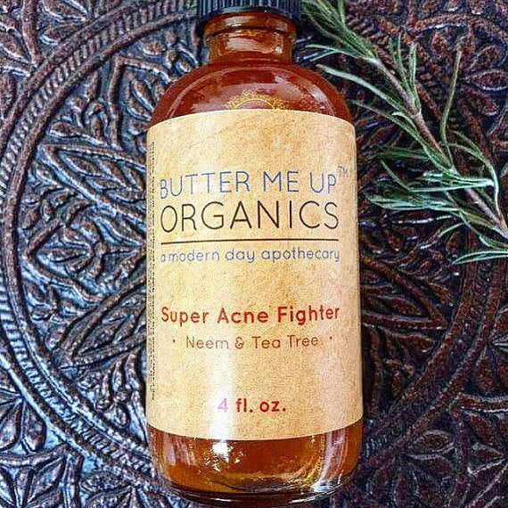 Bottle of 'Super Acne Fighter' from Butter Me Up Organics on a textured background. deep hydrating body butter for winter dry skin and online store. Axis-Dynamics
