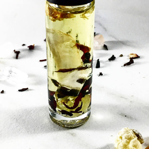 Clear glass bottle filled with a liquid containing floating herbs and spices on a white background. deep hydrating body butter for winter dry skin and online store. Axis-Dynamics