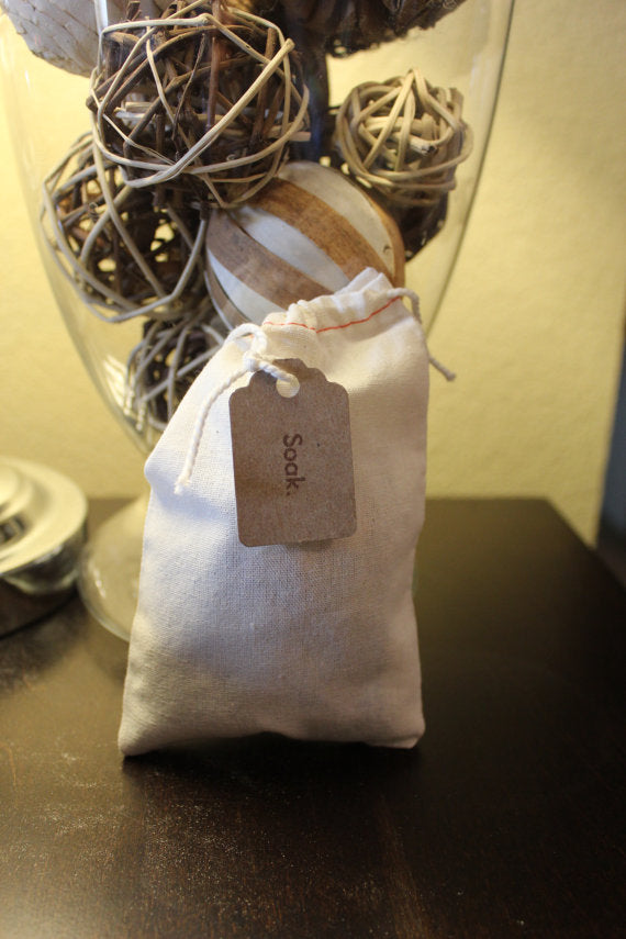 White drawstring bag with a brown tag on a dark surface. Best online retail store. Axis-Dynamics