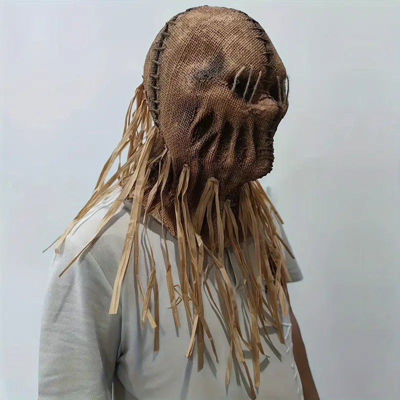Person wearing a unique brown mask with long fringes on a plain background