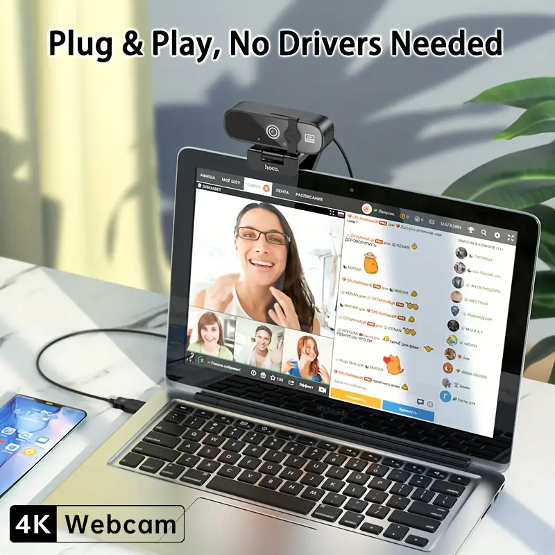 Laptop with 4K webcam on a desk, showing a video call interface.