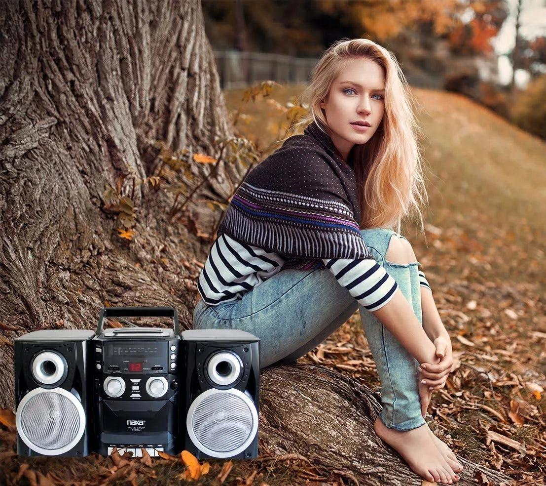 Woman sitting by a tree with a boombox in the foreground