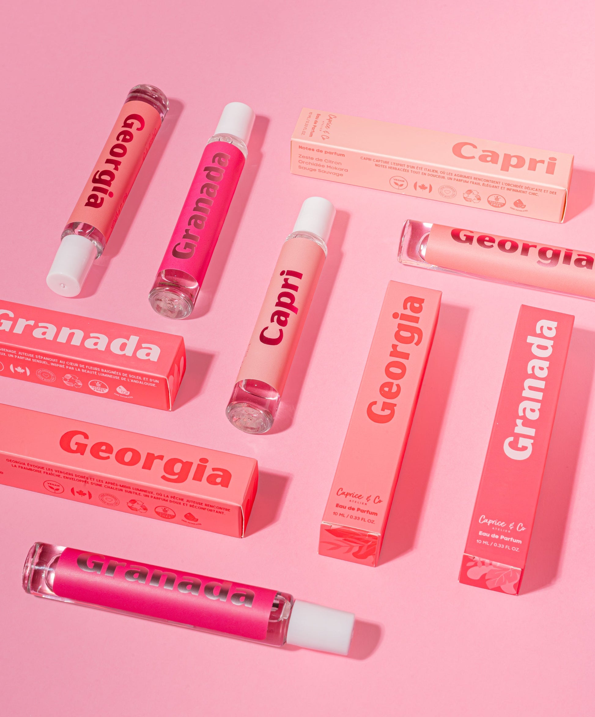 Pink lip gloss products with 'Georgia' and 'Capri' branding on a pink background. Best online retail store. Axis-Dynamics