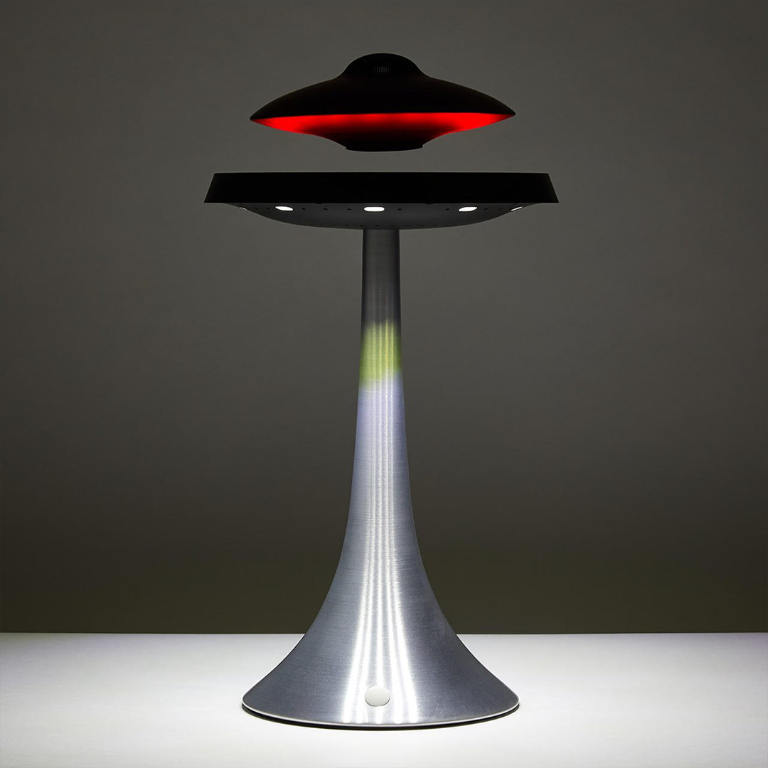 Futuristic UFO-shaped lamp with red light on a dark background